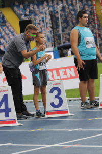 Uczniowei wraz z trenerem na lini startu biegu.