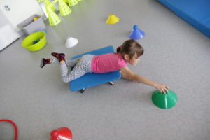 Dziewczynka ćwicząca na desce rotacyjnej.