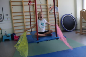 Dziewczynka podczas ćwiczeń na platformie terapeutycznej.