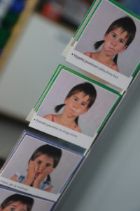 Zdjęcia etykiet wizerunków twarzy prezentujących ćwiczenia logopedyczne.