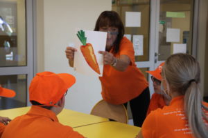 Prowadząca spotkanie prezentująca uczestnikom ilustrację marchewki.