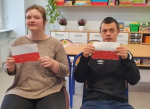 Podopieczni prezentujący wykonane przez siebie flagi Polski.