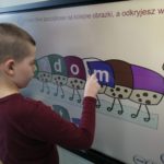 Chłopiec podczas zadania logopedycznego z wykorzystaniem tablicy interaktywnej.
