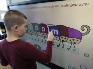 Chłopiec podczas zadania logopedycznego z wykorzystaniem tablicy interaktywnej.