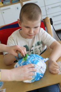 Uczeń podczas wykonywania przestrzennej pracy plastycznej "planeta ziemia".