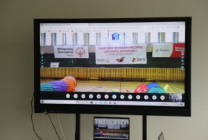 Ekran tablicy interaktywnej z obrazem fragmentu Ceremoni Otwracia wydarzenia.