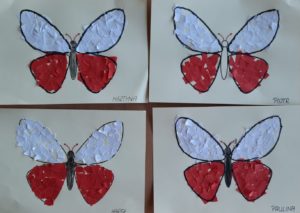 Prace plastyczne - wyklajone biało czerwonymi skrawkami papieru motyle.