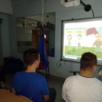Grupa uczniów obserwująca patriotyczną prezentacje na tablicy multimedialnej.