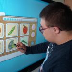 Uczeń pracujący na tablicy interaktywnej - zadanie dotyczące znajomości warzyw.