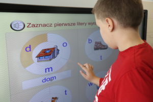Uczeń podcza zadania logopedycznego z wykorzystaniem tablicy interaktywnej.