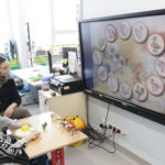 Uczeń wraz z teraputą AAC podczas zadania wyboru odpowiedniego zwierzęcia na tablicy interaktywnej z wykorzystanie specjalistycznej myszki.