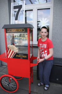 Uczeń pozujący z maszyną do popcornu.