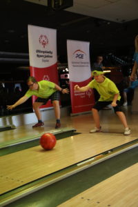 Uczestnicy turnieju w trakcie rzutu kulą bowlingową.