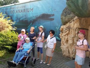 Ekipa uczestników półkolonii pozująca na tle oceanarium.