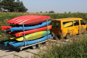Kajaki na przyczepie transportowej w ramach przygotowania do wodowania na rzece.