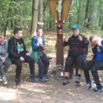 Ekipa podopoiecznych Szkoły Życia w Rybniku podczas odpoczynku w lesie w trakcie grzybobrania.