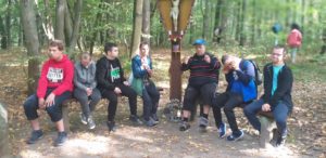 Ekipa podopoiecznych Szkoły Życia w Rybniku podczas odpoczynku w lesie w trakcie grzybobrania.