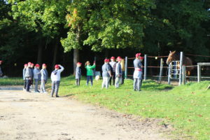 Uczestnicy wyjazdu na pikniku FIT Olimpiad Specjalnych podczas obserwacji konia na wybiegu.