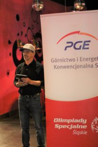 Prezez KS SIlesia Rybnik podczas ceremonii otwarcia turniej, stojący obok roluppu z logotypem PGE.