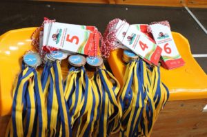 Medale oraz ozdobne wstążki zawodów pływackich.