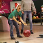 Zawodnik w asyście rodzica grający w bowling.