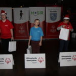 Ceremonia wręczenia upominków w ramach mikołajkowego turnieju bowlingowego, w tle rollupy z logotypami Maista Rybnika, MOSiR-u, ZS-R w Rybniku