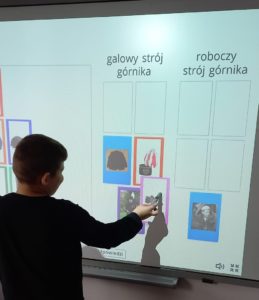 Uczeń podczas tematycznego zadania przy tablicy interaktywnej w ramach tematu Dzień Górnika.