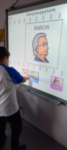 Uczeń wykonujący tematyczne zadanie "Babcia/PCS" na tablicy interaktywnej.