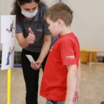 Młody sportowiec podczas obserwacji symboli PCS konkurencji biegowej i rzutnej.