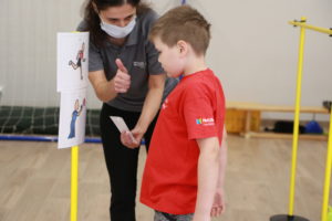 Młody sportowiec podczas obserwacji symboli PCS konkurencji biegowej i rzutnej.