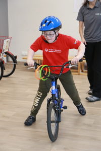 Młody Sportowiec podczas jazdy na rowerze biegowym.