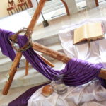 Dekoracja wielkopostna ołtarza (krzyż z filoetowym suknem, chleb, pismo św., wino, korona cierniowa.