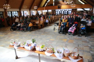 Uczestnicy szkolnych rekolekcji wielkopostnych podczas mszy św., na pierwszym planie eksponowane koszyczki wielkanocne.