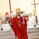 Biskup podczas głoszenia kazania na tle ołtarza.