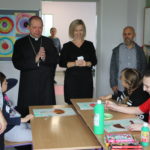 Biskup, proboszcz, dyrekcja placówki oraz uczniowie podczas wizyty w klasie.