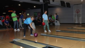 Zawodnicy bowlingu podczas gry na torach bowlinowych.