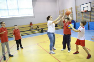 Uczestnicy integracyjnych gier i zabaw podczas aktywności z piłkami.
