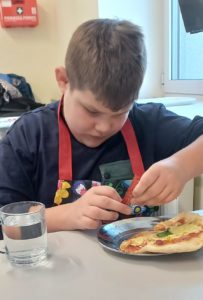 Uczeń podczas konsumpcji pizzy.