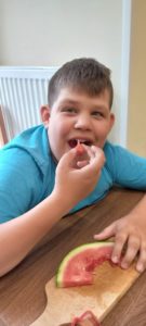 Uczeń jedzący kawałek arbuza