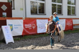 Zawdoni podczas kjazdy na koniu prowadzonym przez trenera.