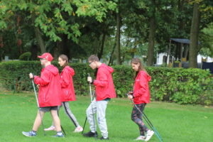 Uczestnicy pikniku podzcas marszu nordic walking.