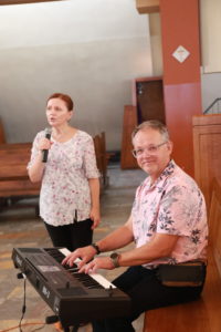 Katechetkapodczas śpiewy do mszy oraz nauczyciel muzyki grający na organach elektrycznych.