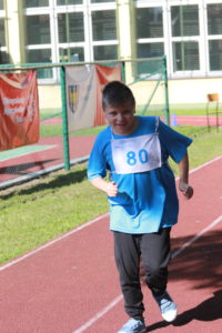 Zawodnik podczas biegu na bieżni lekkoatletycznej.
