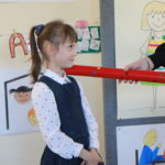 Uczeń podczas pasowania na ucznia wielkim ołówkiem