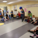Przedszkolaki podczas zabawy muzyczno - ruchowej z clownem.
