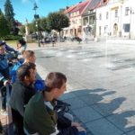 Uczniwie obserwujący fontannę na żorskim rynku.