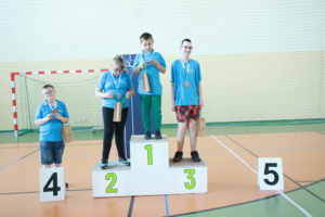 Zawodnicy pozujący z medalami na podium.