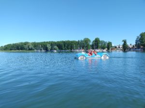 Grupa sportowców podczas aktywności na rowerku wodnym w jeziorze.